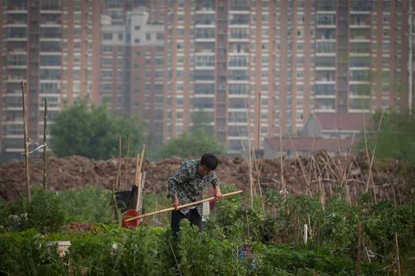 China has launched a debt-for-bond swap program aimed at giving provinces and cities some breathing room in repaying debts. A Chinese peasant farms a field in suburb in Wuhan, Hubei.